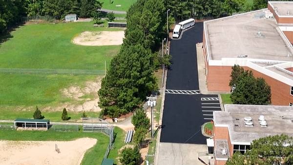 Repaved school campus drive with fresh striping, aerial view