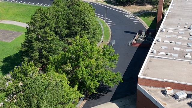 Curved parking lot with new asphalt and striping, aerial view