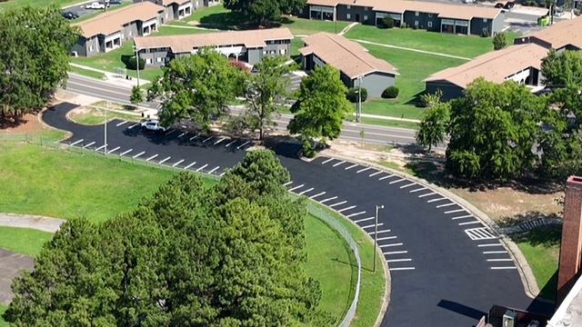 Repaved and restriped parking lot beside a public road